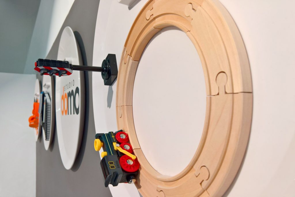 Highlight mit Fernwirkung sind die an der Wand montierten Tabletts des Beistelltischs Porter - hier mit einer Holzeisenbahn und Spielzeugampel